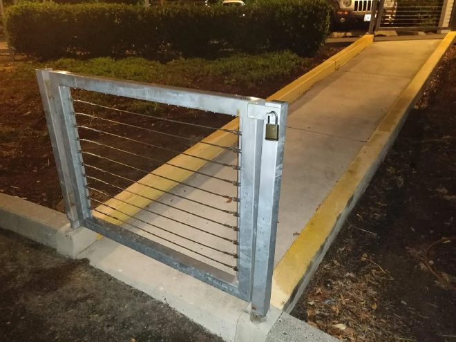 picture of a gate, locked with a padlock, which is free-standing and not connected to a fence, allowing anyone to simply walk around it, illustrating the pointlessness of a lock which is improperly installed